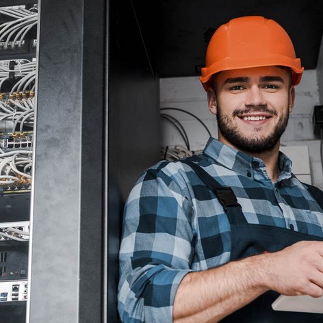 Ein Elektroniker der in einem Serviceraum ein Tablet bedient